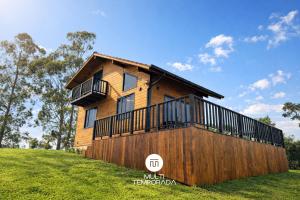a house on a hill with a balcony on it at Chalé do Campinho - Rancho Queimado/SC in Rancho Queimado