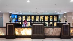 a lobby with a bar with a person sitting at it at Maidan Al Bait in Mecca