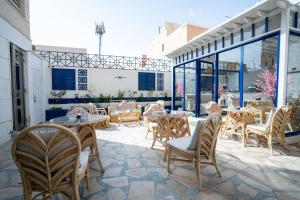 a patio with wooden chairs and tables and windows at شقق جلف نايت للشقق المخدومة in Riyadh