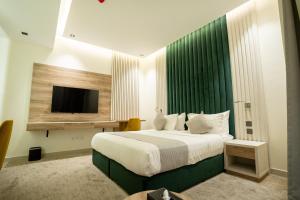 a bedroom with a large bed with a tv on the wall at شقق جلف نايت للشقق المخدومة in Riyadh +75 photos