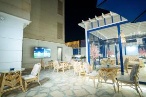 a patio with chairs and tables and a tv at شقق جلف نايت للشقق المخدومة in Riyadh
