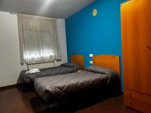 a room with two beds and a blue wall at Hostal Casa Casado in Belver
