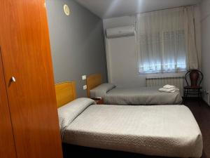 a small room with two beds and a window at Hostal Casa Casado in Belver +4 photos