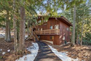 a log house with a balcony in the woods at Creekside Retreat in Whitefish