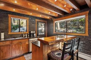 a kitchen with wooden cabinets and a counter with chairs at Creekside Retreat in Whitefish