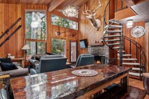 a living room with a fireplace and a spiral staircase at Creekside Retreat in Whitefish +28 photos