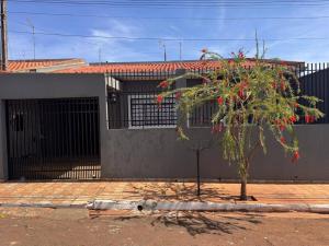 a tree in front of a house with a building at Casa espaçosa com ar em todos os quartos in Ourinhos +21 photos