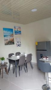 a dining room with a table and chairs and a refrigerator at Casa acogedora in Veracruz