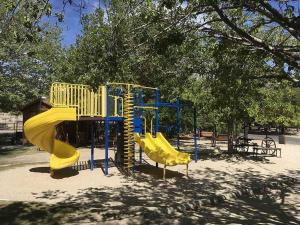 a playground with a slide in a park at Boulder Creek RV Resort in Lone Pine