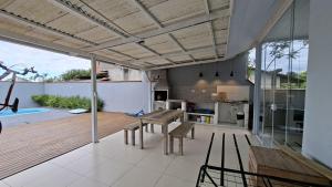 a kitchen and living room with a table and chairs at Villa Di Mare 2 - Pool, fire pit, and barbecue grill in São Francisco do Sul