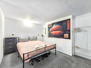 a bedroom with a bed and a painting on the wall at Hidden Putney-Studio Flat in London