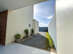 Un pasillo abierto de un edificio blanco con plantas. en Eficiência - Casa Dascli - Sua Casa em Camocim, en Camocim 26 fotos más