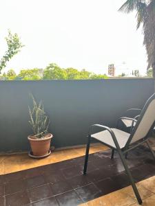 a pair of chairs and a potted plant on a patio at Casa Dos Avenidas 4 Dormitorios in Montevideo