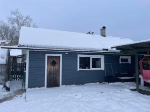 a blue house with a door in the snow at Pusa Saunamaja in Jõhvi
