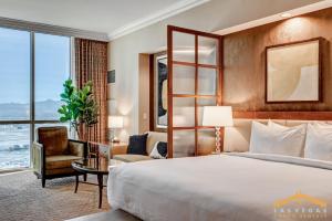 a hotel room with a bed and a desk and a window at MGM Signature 34-818 Jacuzzi Studio Upper Penthouse in Las Vegas