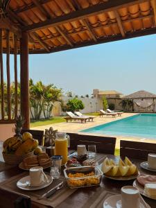 a table with food on it next to a swimming pool at Vila Tao in Fortim