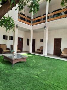 a living room with a table and a green lawn at Laguna Hostal Ocean Beach in San Rafael del Sur