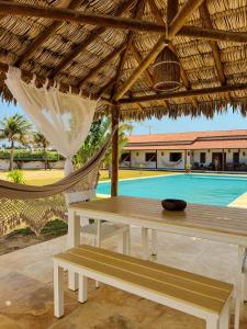 a hammock and a table and a table and a pool at Vila Tao in Fortim