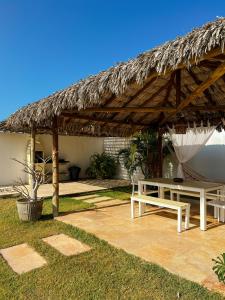 a pavilion with a table and a thatch roof at Vila Tao in Fortim