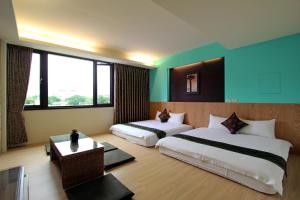 twee bedden in een kamer met blauwe en groene muren bij 開心居-正市中心電梯民宿-步行東大夜市5分鐘 in Hualien