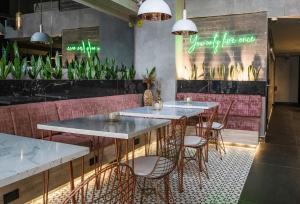 a restaurant with tables and chairs and plants at The O by Seekers Medellín in Medellín +23 photos