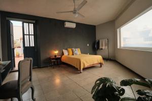 a bedroom with a bed with a yellow blanket and a window at Casa Arrayan in Guadalajara