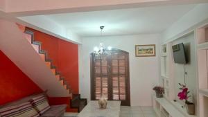 a cat sitting in a living room with a staircase at Sobrado em Coroados, Guaratuba PR in Guaratuba