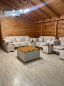 a living room with couches and tables in a room at اكواخ اثينا الفندقية in Jeddah