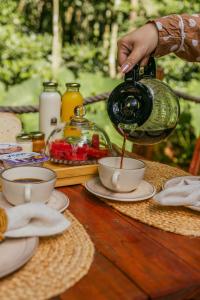 a person is pouring coffee into a cup on a table at Cabana winchesters - Domo in Cascavel