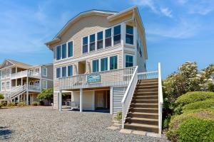 a large house with stairs leading up to it at HB303 My Flippin' House in Holden Beach