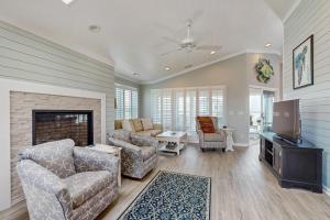 a living room with a couch and a tv at HB303 My Flippin' House in Holden Beach