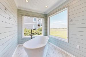 a bath tub in a room with a window at HB303 My Flippin' House in Holden Beach +22 photos