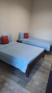 two beds sitting next to each other in a room at Laguna Hostal Ocean Beach in San Rafael del Sur