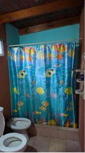 a bathroom with a shower curtain with fish on it at Posada Ernesto in Rauch
