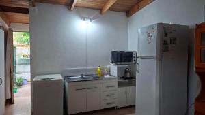 a kitchen with a white refrigerator and a sink at Posada Ernesto in Rauch