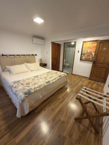 a bedroom with a large bed and a wooden floor at Tierra & Vino a pasos Museo y Casino in Santa Cruz +30 photos