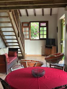 a living room with a red table and chairs at La Villa Terracotta - Vue mer panoramique in Le Diamant