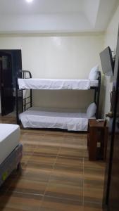 two bunk beds in a room with a wooden floor at Laguna Hostal Ocean Beach in San Rafael del Sur +1 photo
