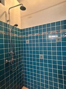 a bathroom with a shower with blue tiles at La Villa Terracotta - Vue mer panoramique in Le Diamant +31 photos