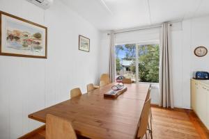 a dining room with a wooden table and a window at Moonah on Mawson in Anglesea