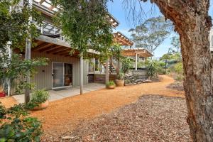 an exterior view of a house with a tree at Moonah on Mawson in Anglesea