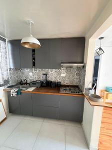 a kitchen with a sink and a stove top oven at Soul Home in Momoxpan