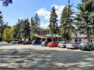 a parking lot with cars parked in front of a building at Vistula Hotel in Świecie