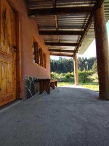 a porch of a building with a wooden roof at Casa Terra Monoambiente in El Bolsón