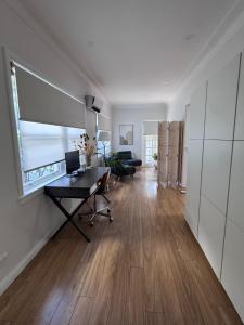 a living room with a desk and a window at Ocean Breeze Cottage in Umina