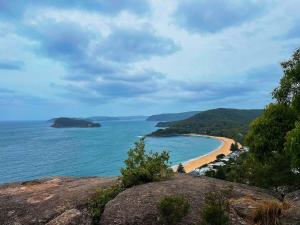 a view of a beach from a cliff at Ocean Breeze Cottage in Umina