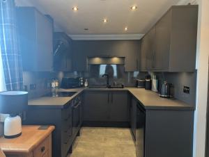 a kitchen with dark blue cabinets and a sink at Whitehouse B&B in Fort Augustus