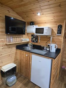 a kitchen with a sink and a microwave at Cosy Cabin - Near Belfast International Airport in Aldergrove