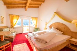 una camera da letto con un letto grande e un tavolo di Hotel Fernblick a San Valentino alla Muta