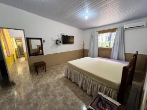 a bedroom with a large bed and a window at Casa da Mata in Ubatuba
